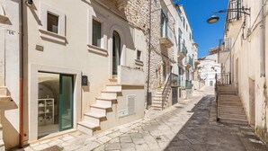 A narrow cobblestone street flanked by historic buildings with arched doorways and balconies. - 2774 Casa Chianchizze by Barbarhouse (Ceglie Messapica)