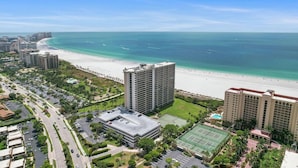 Hotel ved stranden med tennisbane, parkeringsplads og havudsigt.