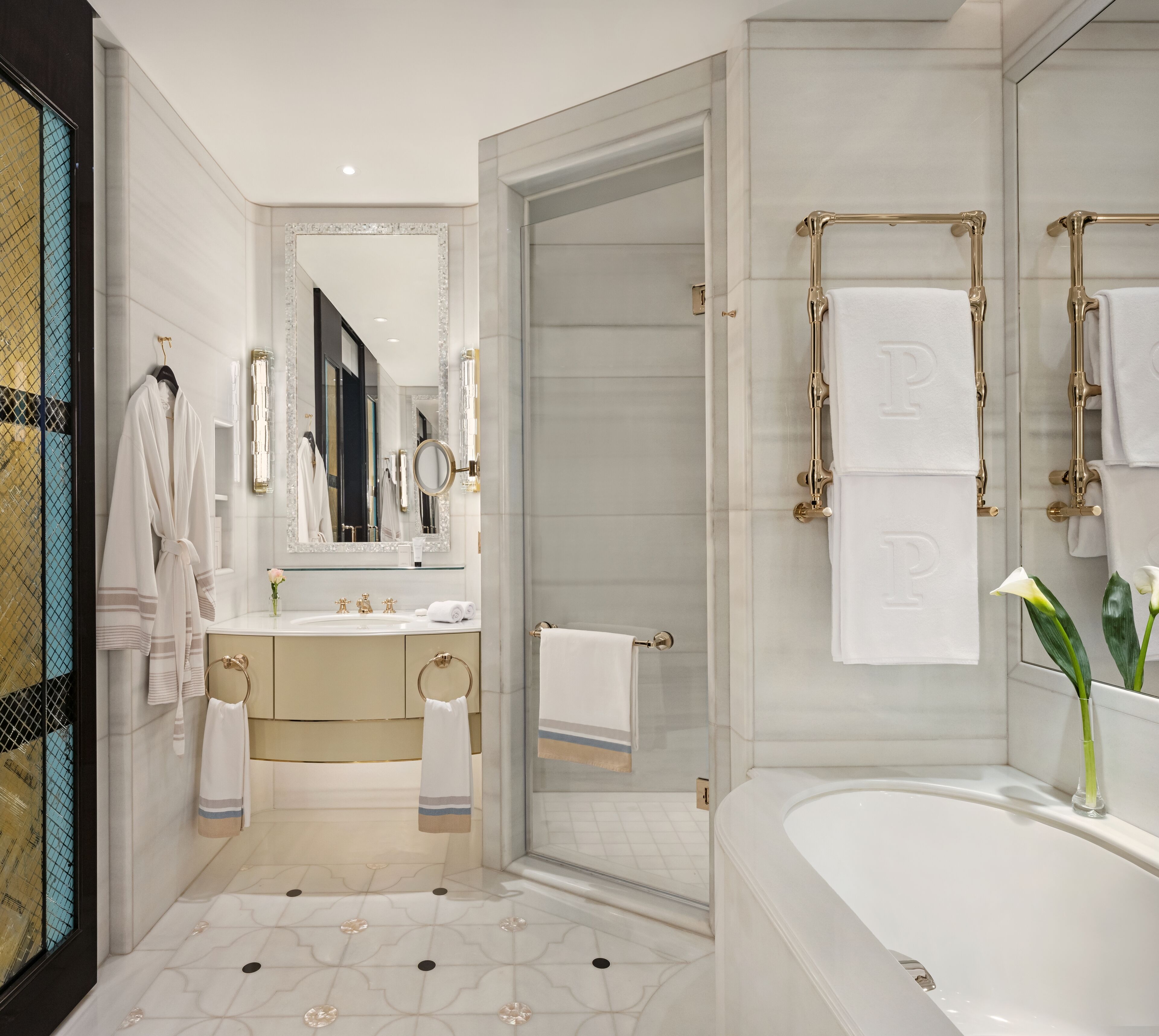 Ein modernes Badezimmer mit einem großen Spiegel, einer Badewanne und einem Waschtisch.