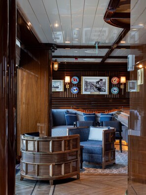 A modern interior with a wooden accent wall, a seating area with blue upholstered sofas, and a wooden coffee table.
