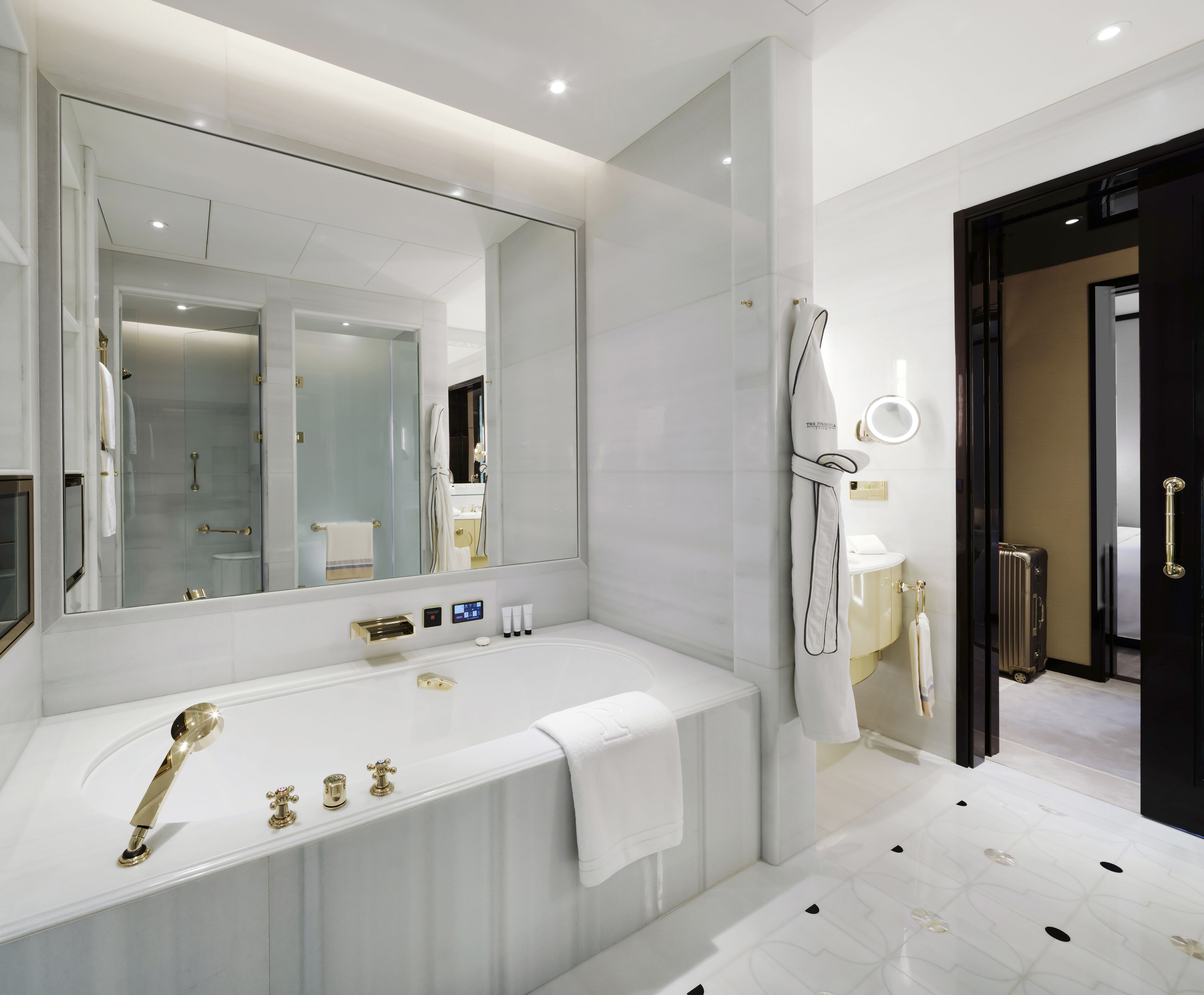 Un baño moderno con un espejo grande, una bañera, una zona de ducha y un inodoro.