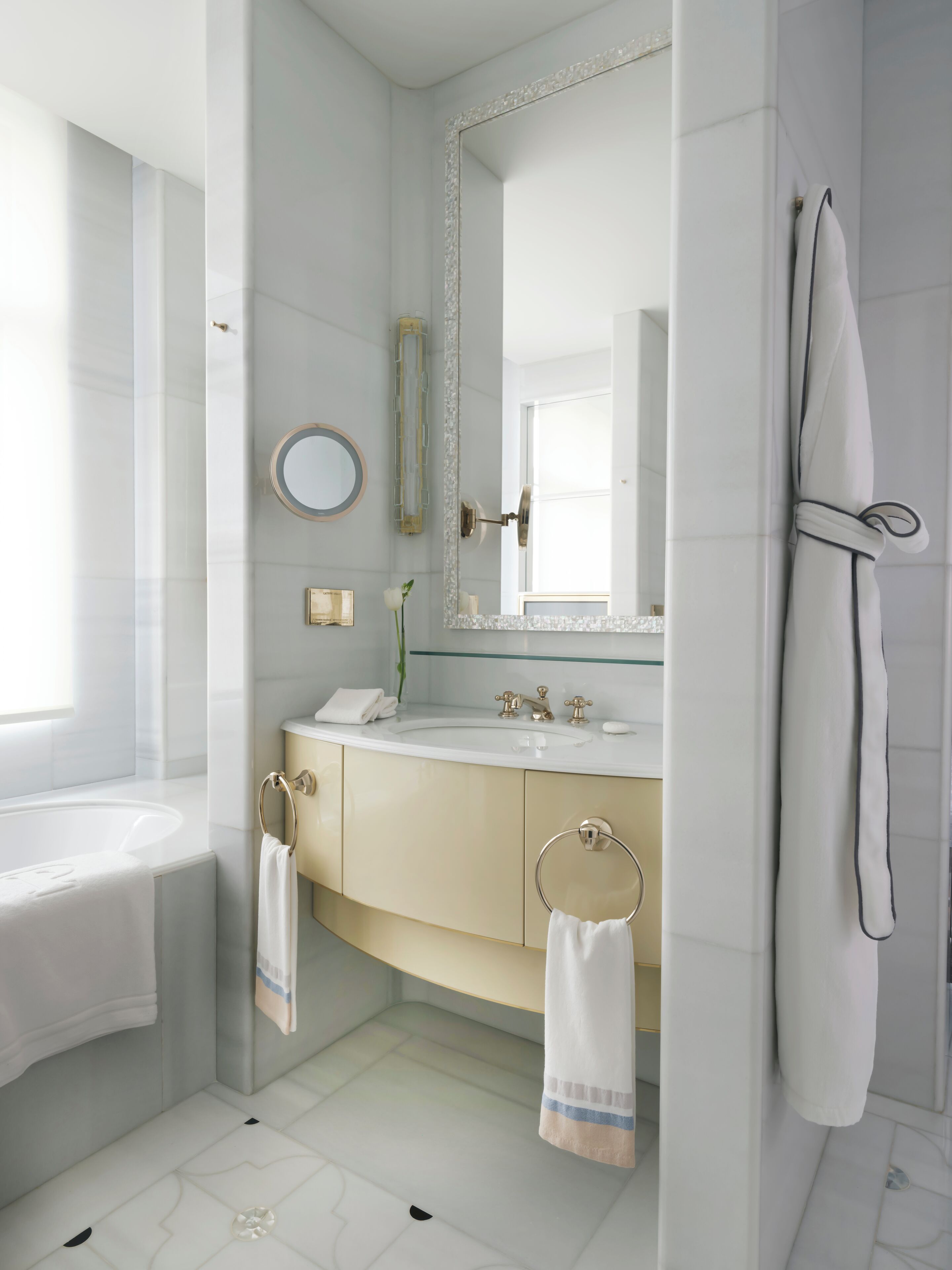 A modern bathroom with a bathtub, a sink with a mirror, and a towel rack.