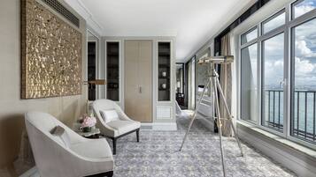 Amplia habitación con un gran ventanal, un trípode y una silla.