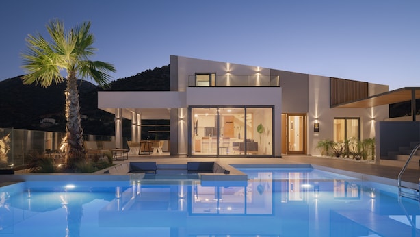 A modern house with a swimming pool, large windows, and a palm tree. - Mayana Luxury Villa, an infinite blue experience (Rethymno)
