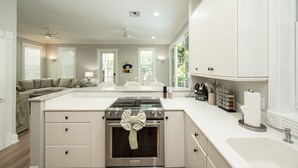 Een ruime keuken met een centraal eiland, een inbouwoven en veel werkruimte.