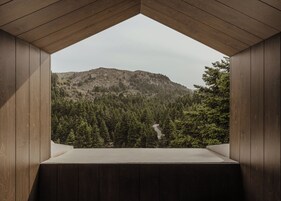 Una habitación con vista a una montaña boscosa.