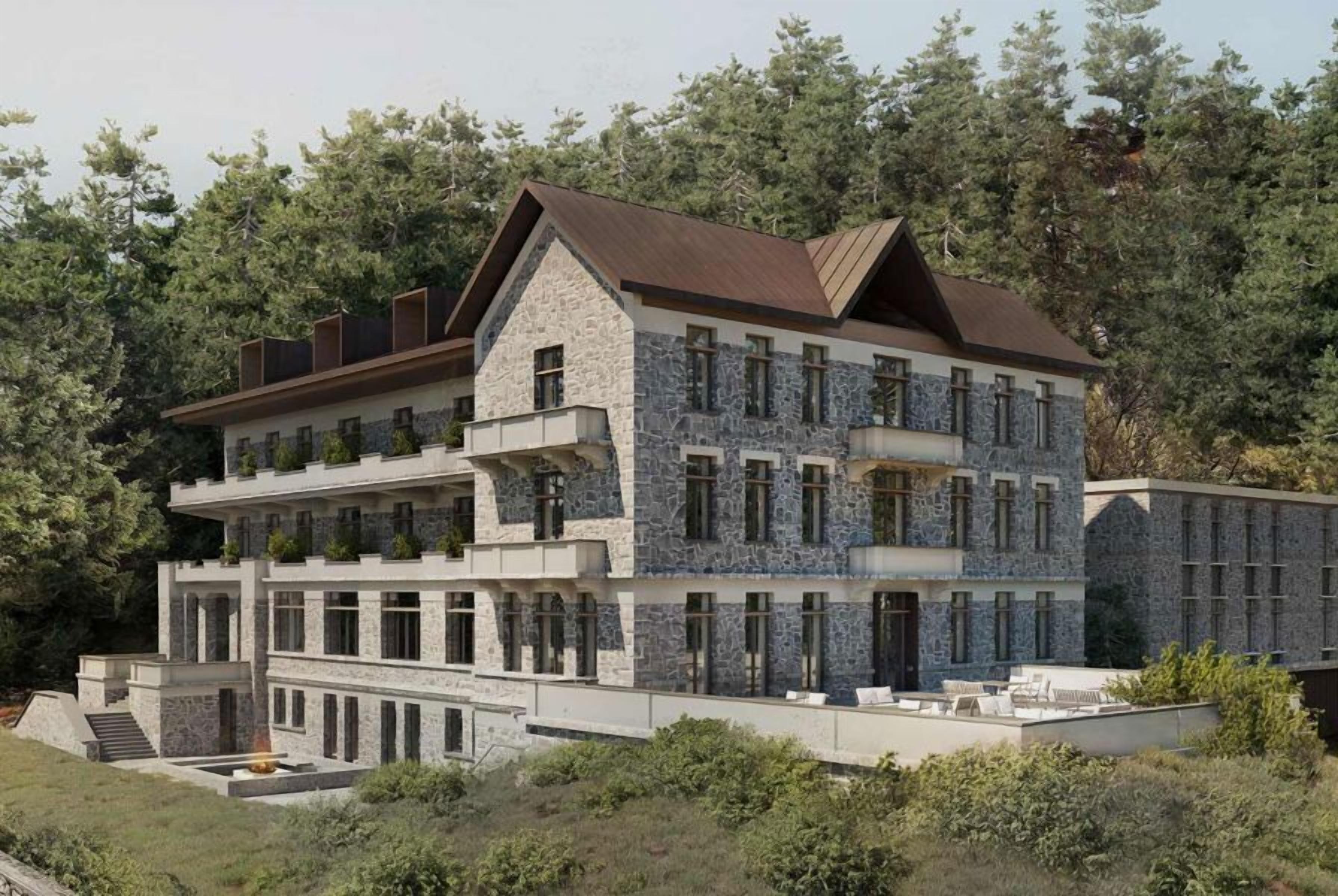 A multi-story building with a stone facade, multiple balconies, and a flat roof.