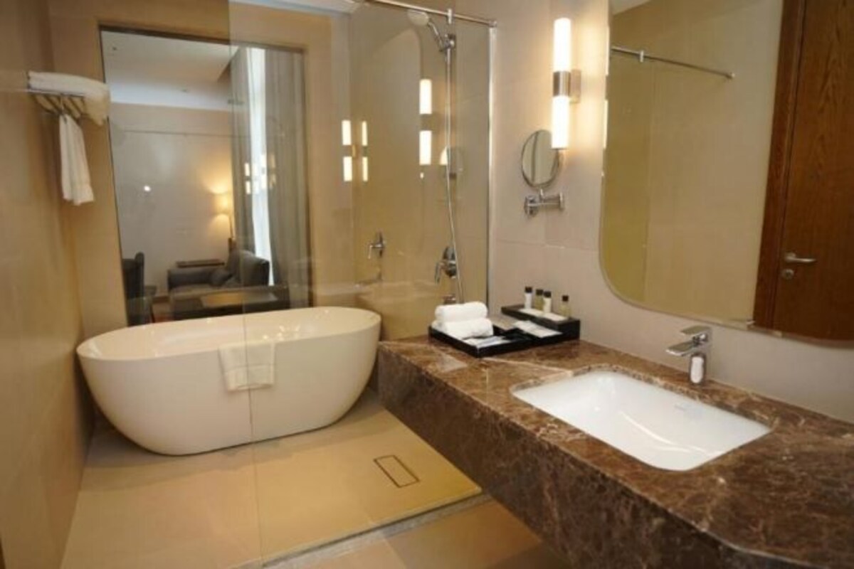 A modern bathroom with a freestanding bathtub, a vanity with a sink, and a large mirror.