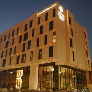 A modern hotel building with multiple floors, large windows, and a prominent sign. - Jasmine Garden Hotel (Jeddah)