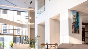 Een ruime lobby met een bank, een salontafel en een eethoek.