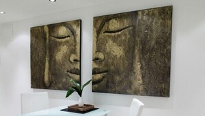 Un comedor moderno con una mesa de vidrio y sillas blancas, con dos grandes cuadros abstractos en la pared.