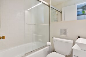 A modern bathroom with a glass shower enclosure, a white toilet, and a sink. - Harvard Square! (Cambridge)