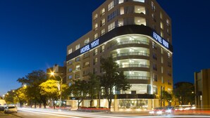A multi-story hotel with a prominent "HOTEL VISIT" sign on the facade. - Visit Hotel & Apart (San Luis)