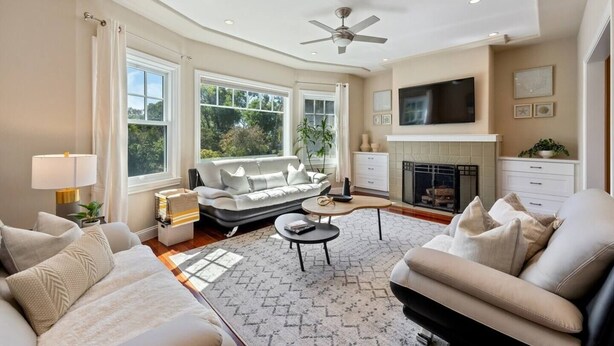 A spacious living room with a sofa, armchairs, a fireplace, and a television. - Refined 3BR Retreat in the Heart of Inner Richmond, Near Presidio, Golden Gate Park & Clement Street (San Francisco)