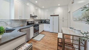 A modern kitchen with white cabinets, stainless steel appliances, and a wooden floor. - Serene Inner Richmond 3BR Retreat Near Golden Gate Park, Clement Street & Geary Blvd (San Francisco)