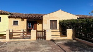 Un bâtiment à deux étages, doté d’un toit en tuiles, d’une entrée fermée par un portail et d’un petit jardin.