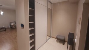 A room with a sliding door closet, a small bench, and a table. - Fresh and lovely apartment (Jurmala)