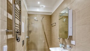 A modern bathroom with a toilet, sink, mirror, shower, and a washing machine. - Fresh and lovely apartment (Jurmala)