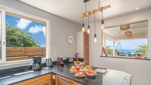 Uma cozinha moderna com uma janela grande, armários de madeira e um espaço para café da manhã no balcão.