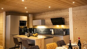 A modern kitchen with wooden ceiling, built-in appliances, and a flat-screen TV. - Apartment for 9 people at 500m from Linga gondola - Chatel Reservation (Châtel)