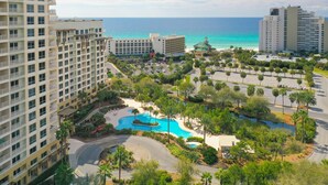 Ein Resort mit mehreren Hochhäusern, einem zentral gelegenen Poolbereich und Blick auf den Ozean.