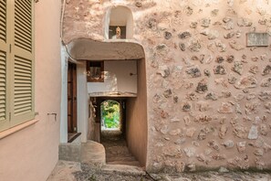 A narrow stone staircase leading to a doorway with a small window above.