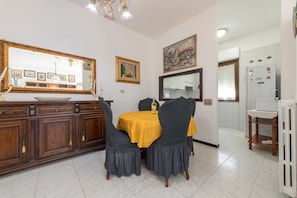 Uma sala de jantar com uma mesa, cadeiras e um espelho.