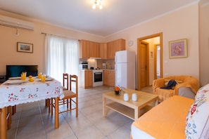 Un espacio habitable compacto con comedor, cocina y zona de estar.
