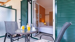 Una habitación con una cama, una mesa con bebidas y una silla.