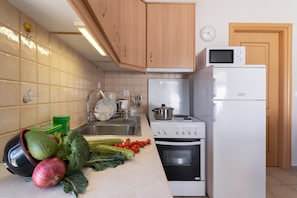 Una cocina equipada con fregadero, estufa, microondas y refrigerador.