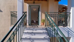 A staircase leading to a room with a bed, a potted plant, and a door. - Apartment "Villa Votistis A1" with Mountain View, Garden & Wi-Fi (Lefkadas)