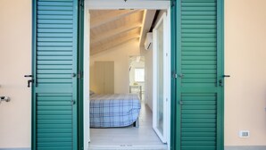Uma porta aberta que dá para um quarto com uma cama e uma janela.