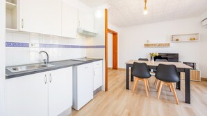 Une cuisine moderne avec des armoires blanches, un comptoir noir et un four à micro-ondes encastré.