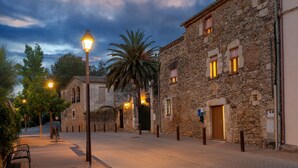 Un bâtiment en pierre doté d’une porte, de fenêtres et d’un lampadaire.