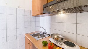 Eine Küche mit Spüle, Herd und Holzschränken.