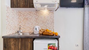 A kitchenette with a sink, a kettle, a loaf of bread, and oranges on the counter. - Nikiana Club Studio 6 with Mountain View & Wi-Fi (Lefkada)