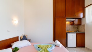 Habitació d'hotel amb llit, petita cuina i bany.