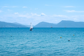 A sailboat on a calm sea with distant mountains.