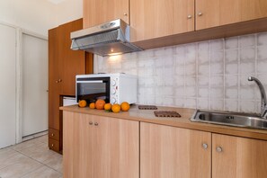 A kitchen with wooden cabinets, a built-in microwave, a sink, and a range hood.