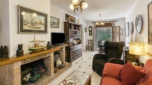 A living room with a fireplace, television, and seating area. - Holiday Home 'Villa Montgó Parc Con Piscina' with Mountain View, Shared Pool and Air Conditioning (L'Escala)