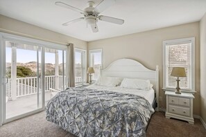 A bedroom with a bed, a nightstand, a ceiling fan, and a balcony with a view. - Make Lasting Memories at 'Memory Maker' | Pool, Hot Tub, Game Room | Perfect for Large Families (Corolla)