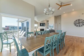 A dining area with a wooden table and teal chairs, a chandelier, and a ceiling fan. - Make Lasting Memories at 'Memory Maker' | Pool, Hot Tub, Game Room | Perfect for Large Families (Corolla)
