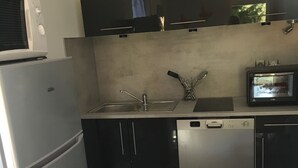 Una cucina compatta con frigorifero, lavastoviglie e forno a microonde.