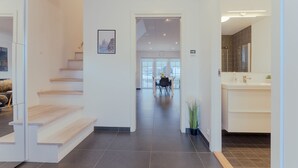 A modern interior with a staircase, a dining area, and a bathroom. - New Boat Houses (Leirvik)