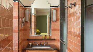 A bathroom with a sink, mirror, and towel rack.