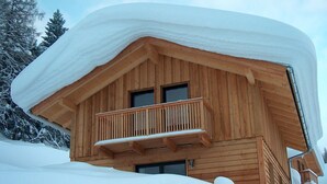 A wooden cabin with a balcony, surrounded by snow-covered trees. - "Almhaus Kleeblatt" cozy vacation home - dreamlike in the ski and hiking area (Annaberg)