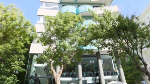 A modern multi-story building with a distinctive architectural design, featuring curved balconies and large windows. - Hotel Ali d'Oro (Rimini)