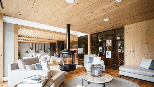 Una sala de estar moderna con chimenea, sofás y una mesa de centro.