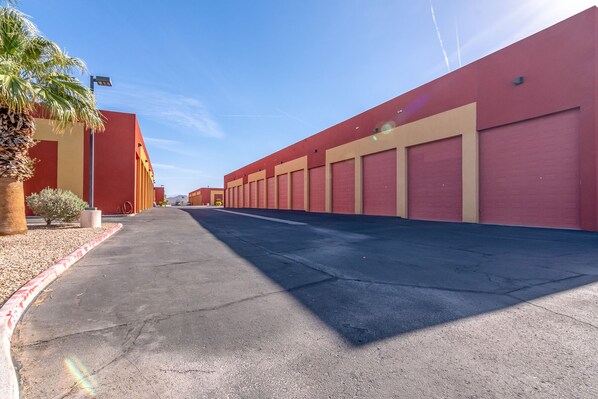 A long row of red and beige buildings with large garage doors, likely a warehouse or industrial complex. - Riverfront Condo w/beach, boat launch, pool & spa (Bullhead City)