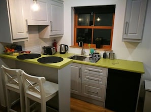Enjoy cooking in this well-equipped kitchen with a sink, kettle, toaster, and refrigerator.